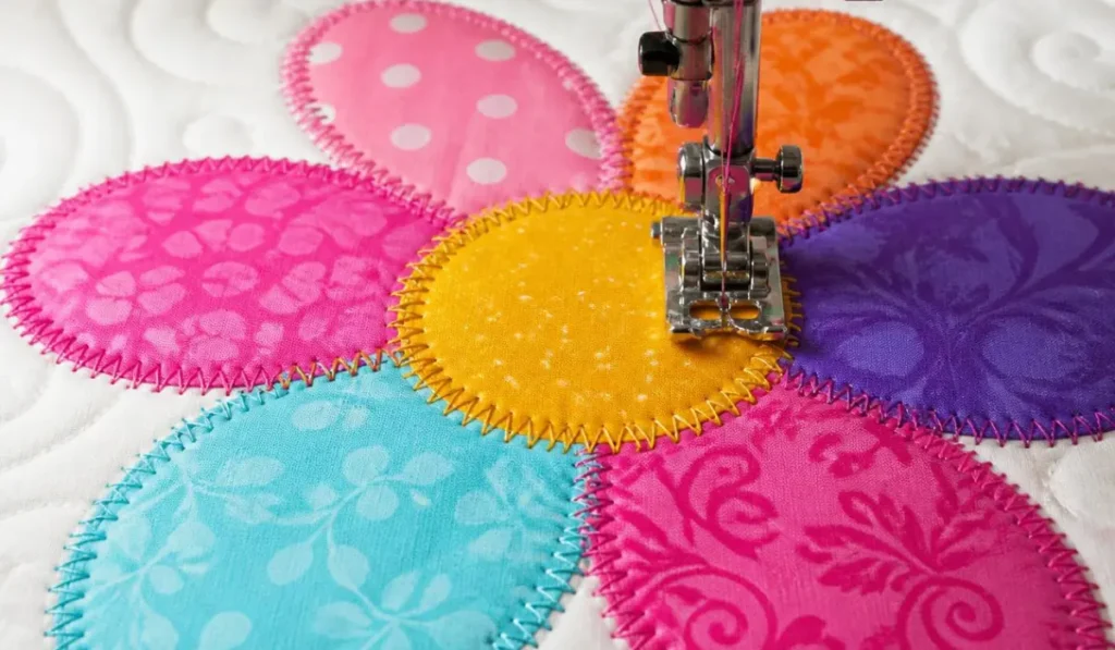 Sewing machine stitching around a colorful flower applique with raw edges,